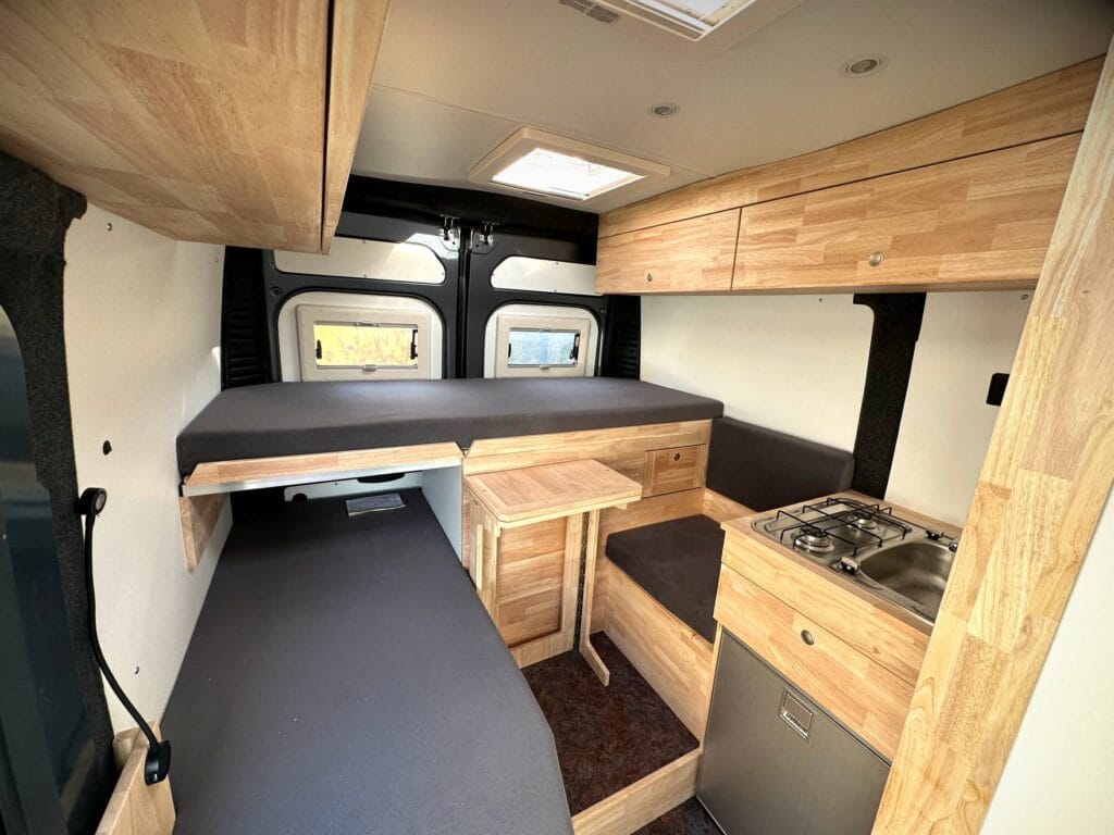 Camping-car compact 2 places par Karr Koncept : intérieur, banquette-lit et cuisine