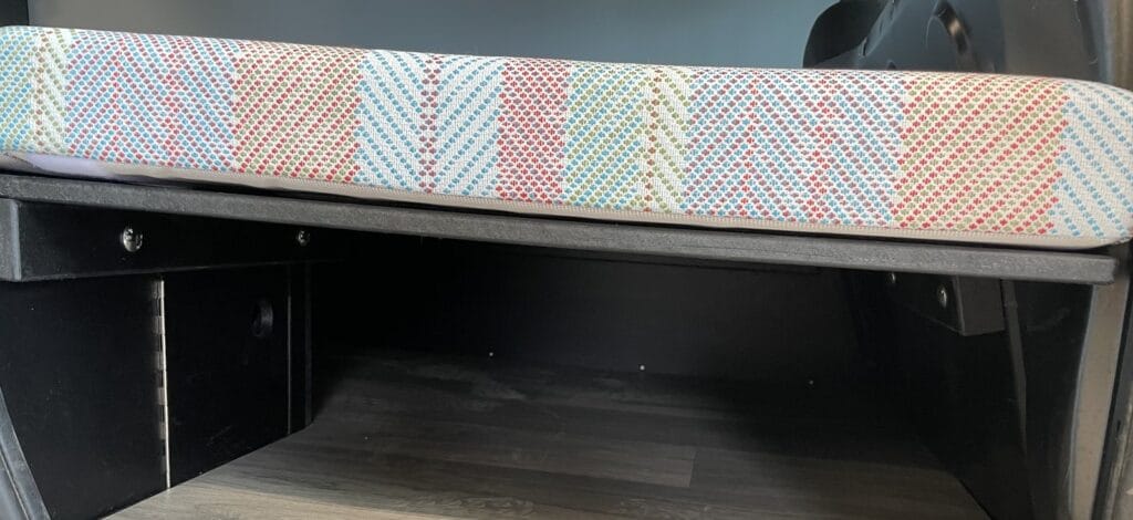 Dormir dans un Kangoo par Karr Koncept : banquette à motif et coffre de rangement ouvert dessous