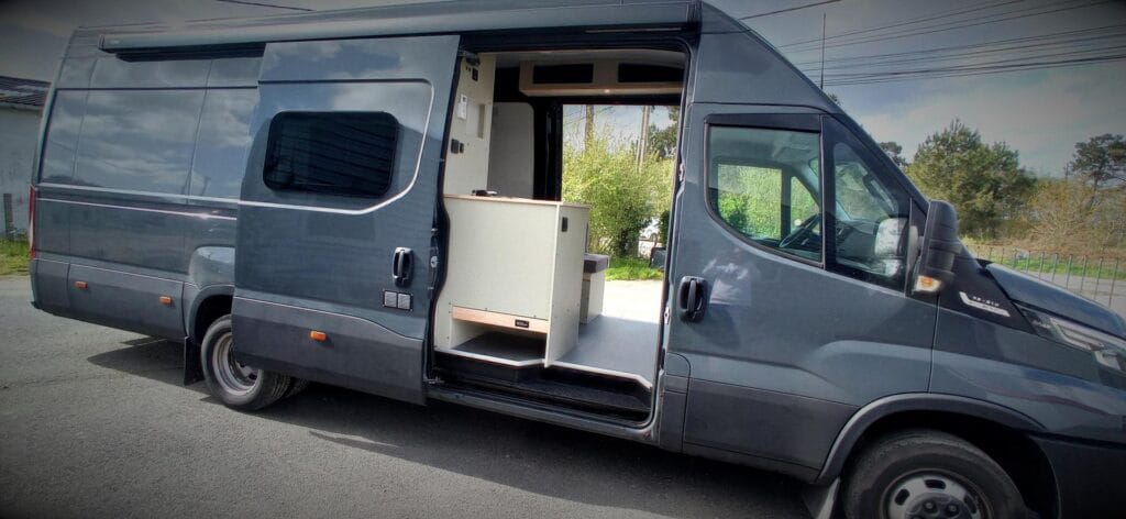 Fourgon atelier camping par Karr Koncept : l'Iveco Daily, porte latérale ouverte sur l'aménagement