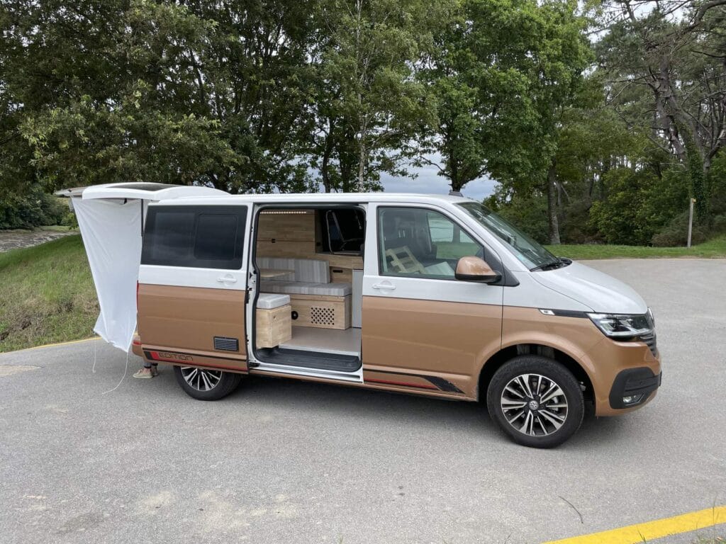 Petit van aménagé par Karr Koncept : le T6 bicolore porte ouverte, au bord du lac