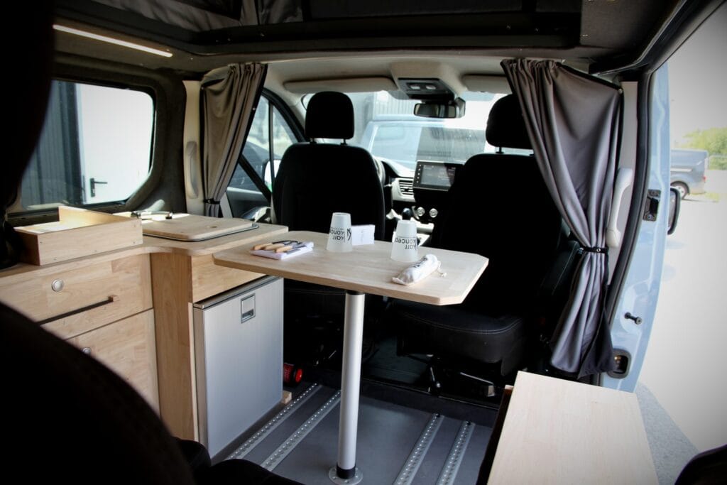 Van 4 places 4 couchages par Karr Koncept : intérieur, table et sièges cabine retournés