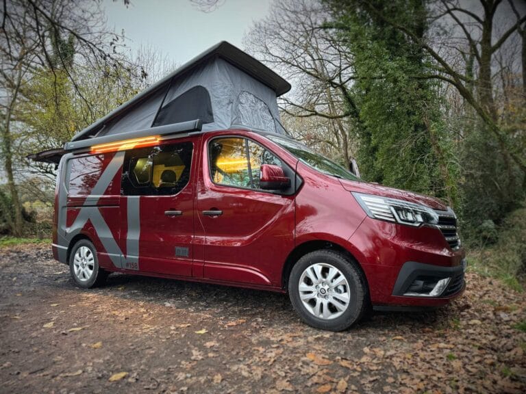 Van 5 couchages par Karr Koncept : le Renault Trafic rouge toit relevé ouvert, en forêt