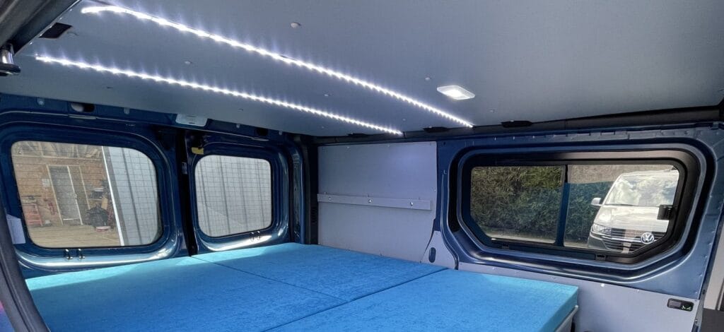Van aménagé plongée par Karr Koncept : bandeau LED du plafond et lit déployé