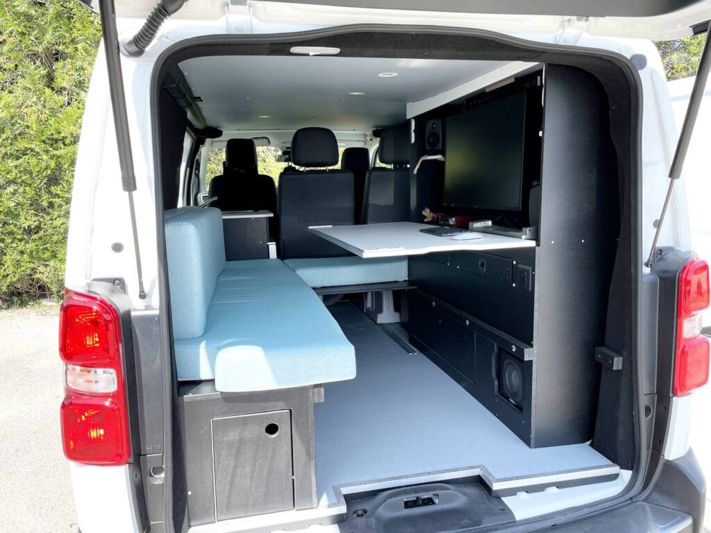 Van bureau mobile par Karr Koncept : vue arrière, bureau avec écran, table et banquette