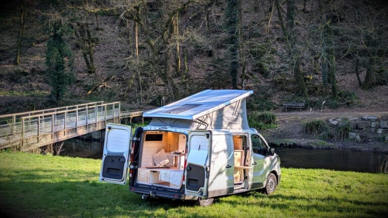Van cocooning par Karr Koncept : le Trafic toit relevé au bord de la rivière, portes ouvertes
