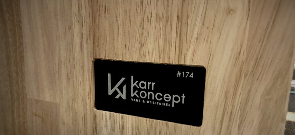 Van familial 4 places par Karr Koncept : veinage du panneau en hévéa massif autour de la plaque