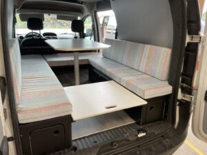 Dormir dans un Kangoo par Karr Koncept : la rallonge de lit posée entre les deux banquettes, vue de trois quarts arrière