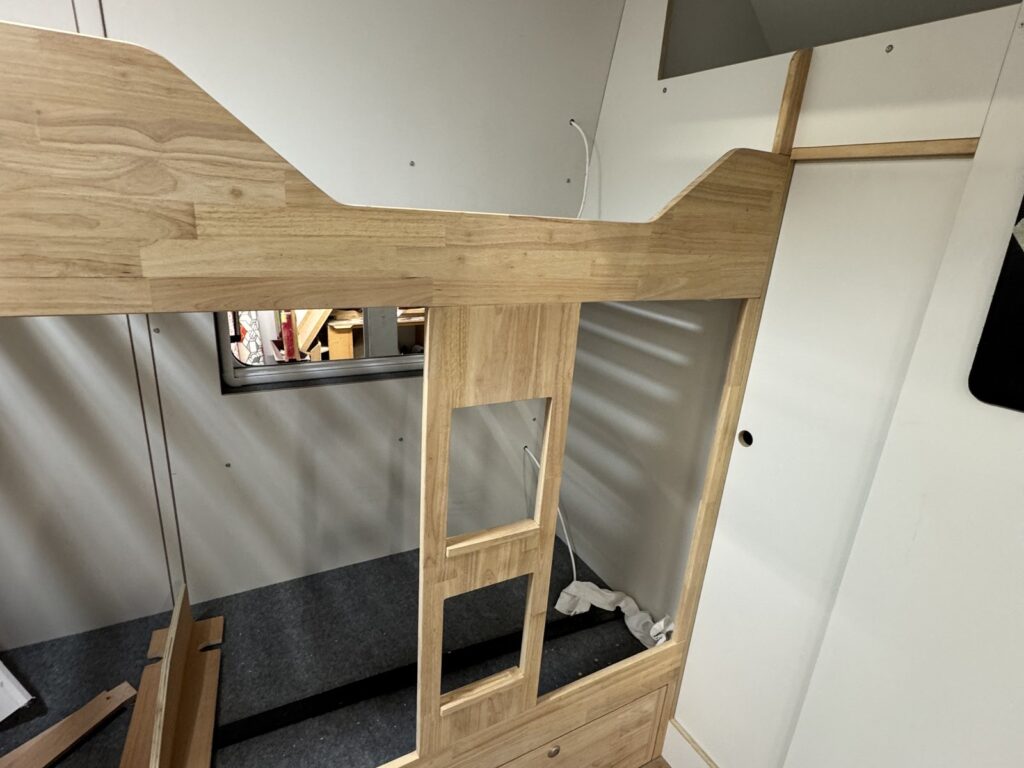 Menuiserie en cours : structure de lits superposés en bois dans un fourgon