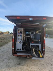 Van aménagé pour transporter un bateau par Karr Koncept : hayon ouvert, sac du voilier Tiwal posé sur le plateau tiroir