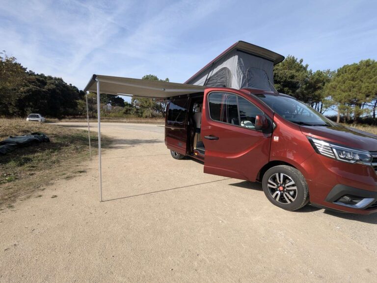 Van aménagé pour transporter un bateau par Karr Koncept : le Renault Trafic rouge aménagé, toit relevable Reimo ouvert et store déployé