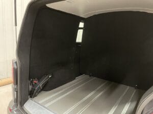 Van cabine approfondie par Karr Koncept : parois du coffre habillées de moquette noire au-dessus du plancher à rails