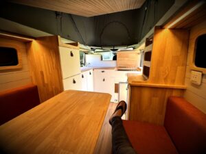 Van cocooning par Karr Koncept : l'intérieur vu vers la cabine sous le toit relevé, un passager installé sur la banquette
