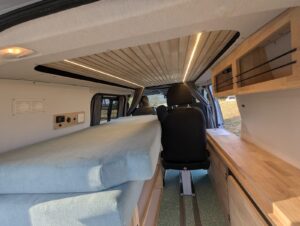 Van salon de massage par Karr Koncept : intérieur avec plafond en lattes de bois massif éclairé et siège sur rails