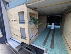 Van salon de massage par Karr Koncept : coffres en hévéa sous la table de massage et rails du siège coulissant